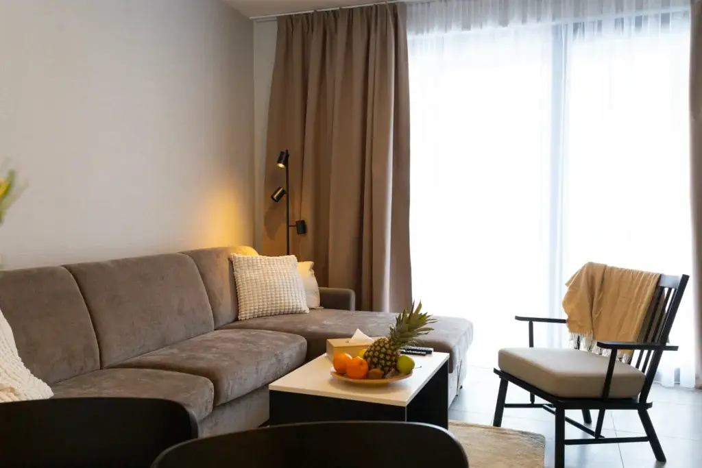 Pohovka a kreslo pri okne vo vzorovom apartmáne LUXURY